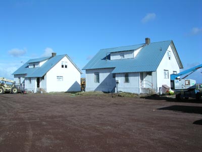 Photo of two of the teacher's houses, white houses against a blue sky.