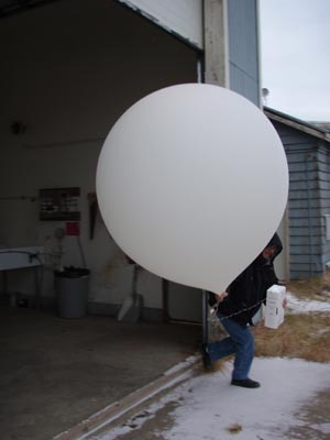 Photo of man with a very large white balloon.